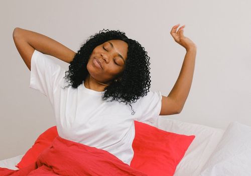 Smiling woman enjoying a peaceful morning stretch at home